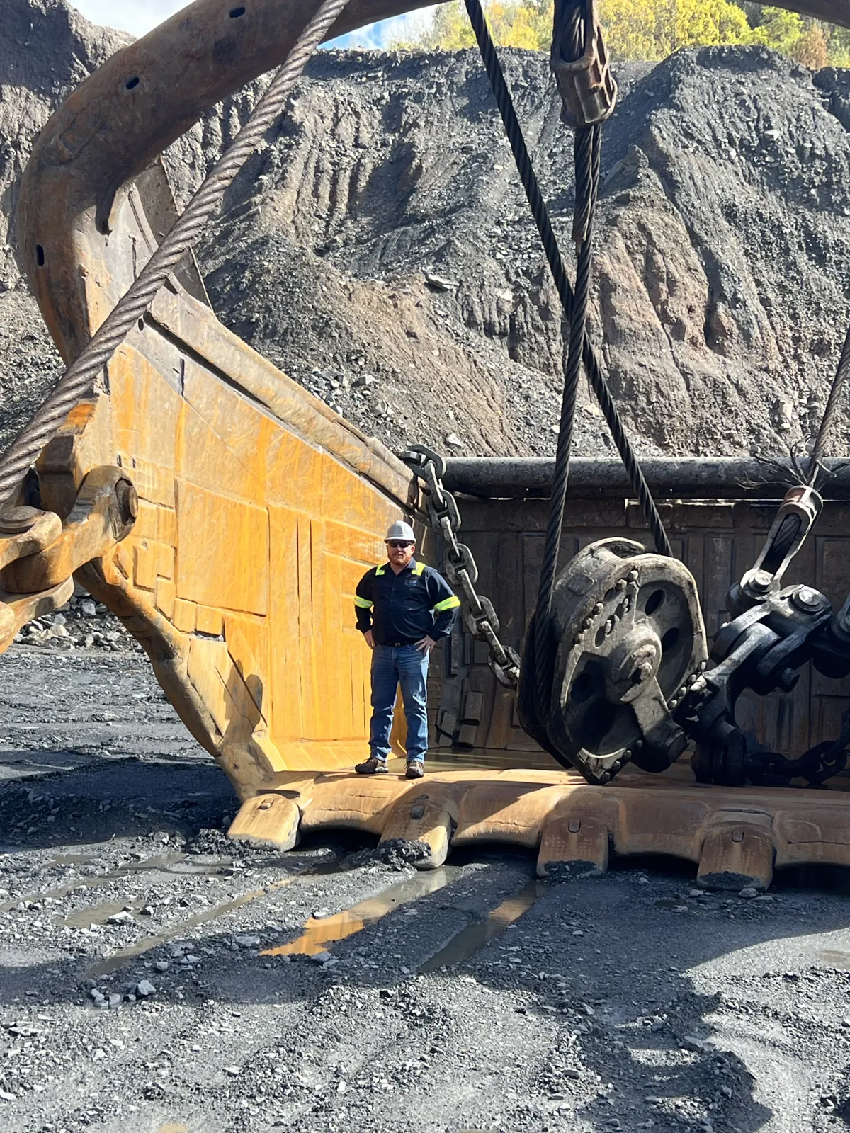 Dragline bucket rigged for a lift with a fitter alongside